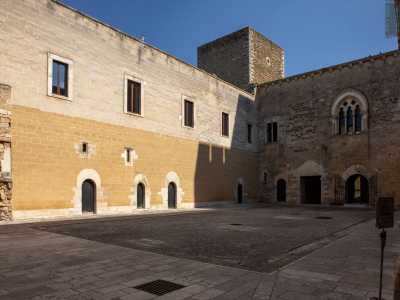 Lo spazio � racchiuso da alte cortine murarie in pietra calcarea chiara e carparo con una sezione inferiore caratterizzata da blocchi di tonalit� dorata e ingressi ad arco a tutto sesto
